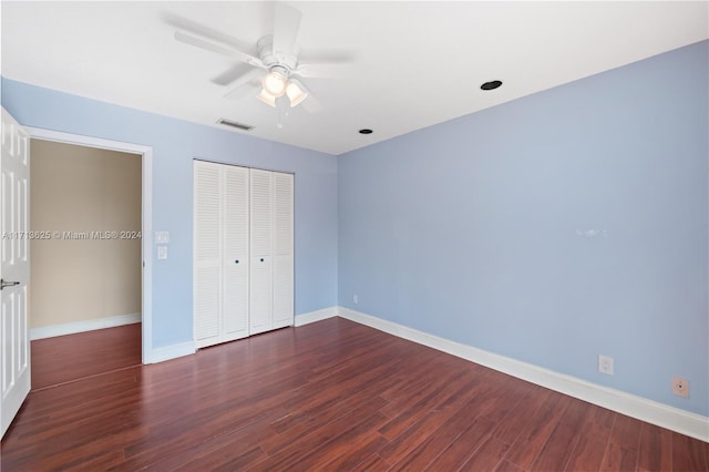 unfurnished bedroom with a closet, ceiling fan, and dark wood-type flooring