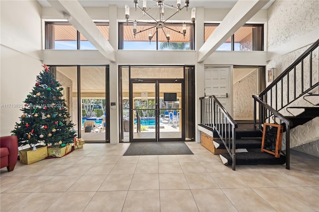1709 Saint Andrews Rd, Hollywood, FL 33021 - foyer with tile patterned floors, healthy amount of natural light, a towering ceiling, a chandelier, and stairs