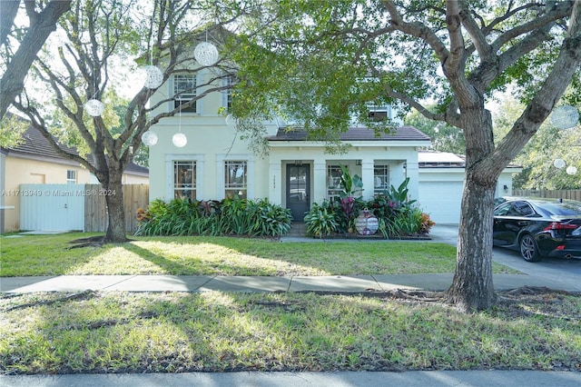 view of front of house with covered porch, a garage, and a front lawn