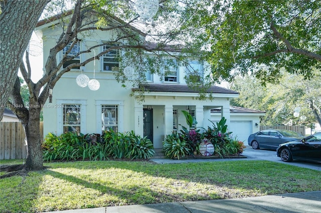 view of front of home with covered porch, a garage, and a front yard