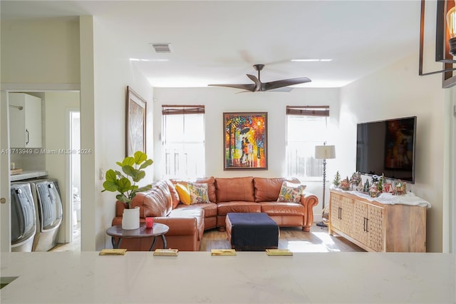 living room with separate washer and dryer, ceiling fan, and plenty of natural light