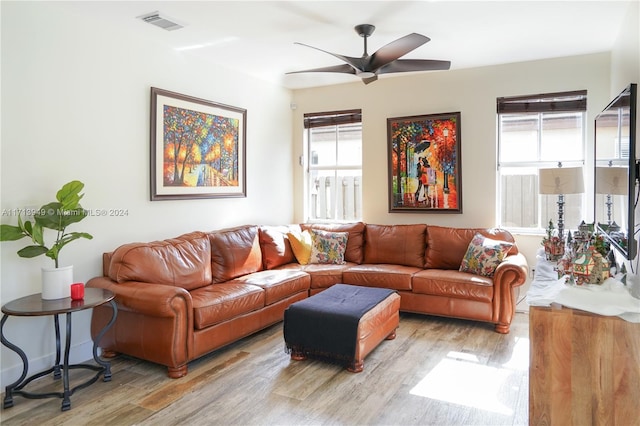 living room with light wood-type flooring, a wealth of natural light, and ceiling fan