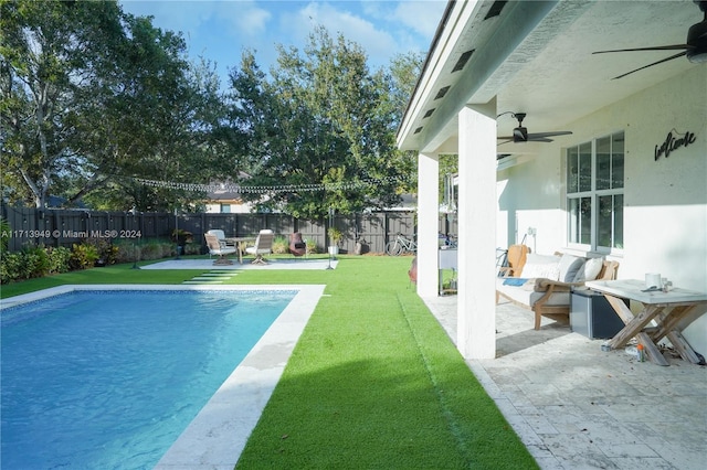 view of pool with a patio, ceiling fan, and a lawn