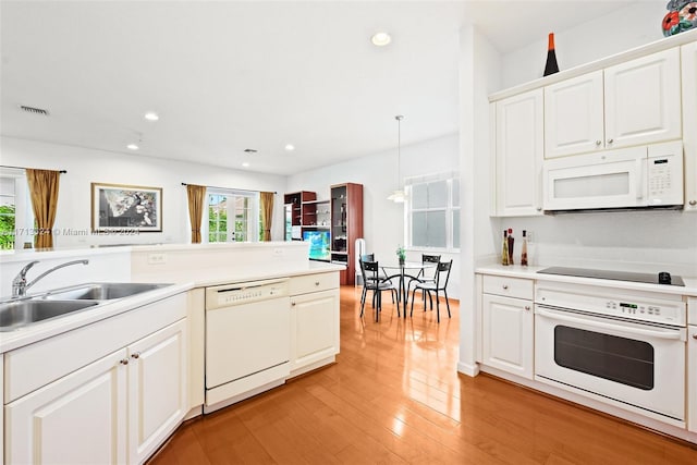 kitchen with white cabinetry, sink, decorative light fixtures, white appliances, and light wood-type flooring