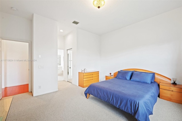 carpeted bedroom featuring ensuite bath