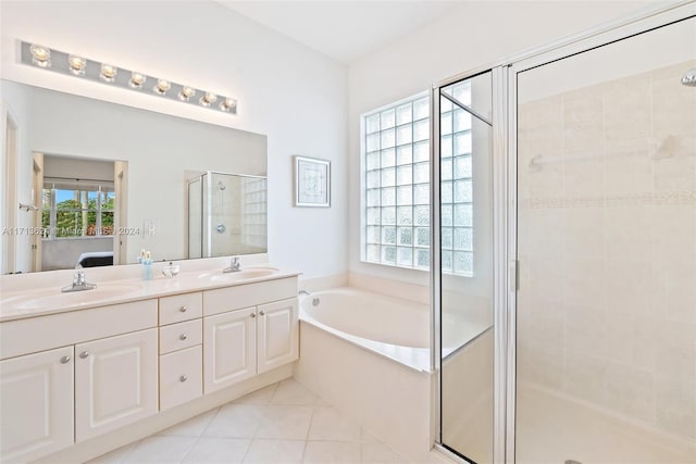 bathroom featuring plus walk in shower, tile patterned flooring, and a healthy amount of sunlight