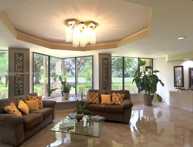 living room with a notable chandelier and a tray ceiling