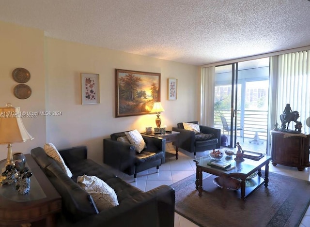 living room featuring light tile patterned floors, a textured ceiling, and a wall of windows