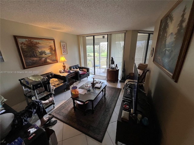 living room featuring tile patterned floors, a wall of windows, and a textured ceiling