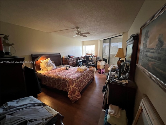 bedroom featuring dark hardwood / wood-style flooring, a textured ceiling, and ceiling fan