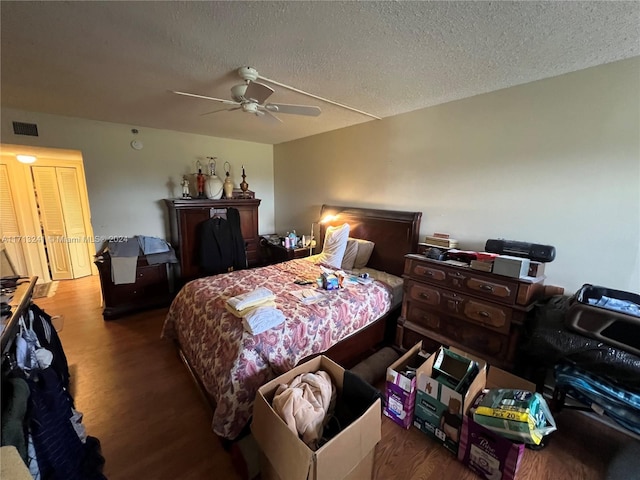 bedroom featuring hardwood / wood-style flooring, ceiling fan, and a textured ceiling