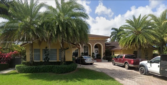 mediterranean / spanish house featuring a front lawn