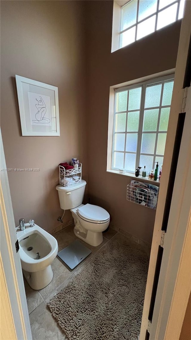 bathroom featuring tile patterned flooring, a bidet, and toilet