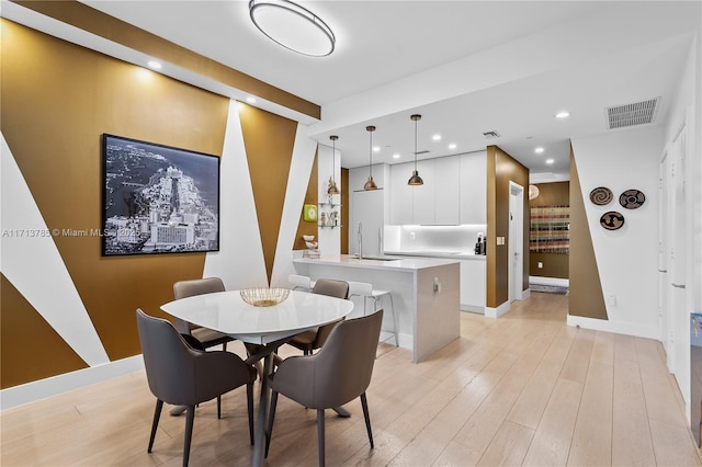 dining room featuring sink and light wood-type flooring