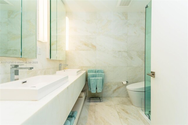 bathroom with tile walls, vanity, and toilet