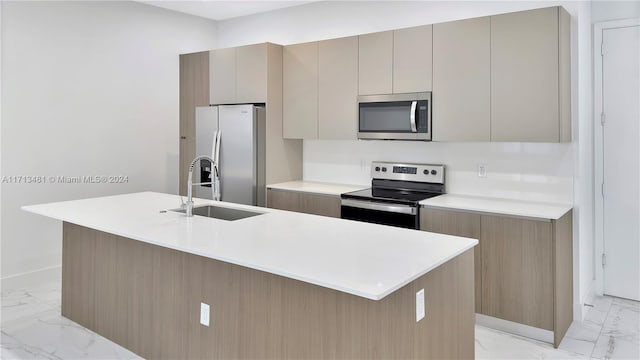 kitchen featuring a kitchen island with sink, sink, and appliances with stainless steel finishes