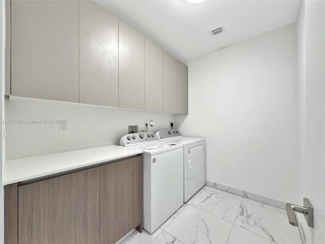 laundry area featuring washer and clothes dryer and cabinets