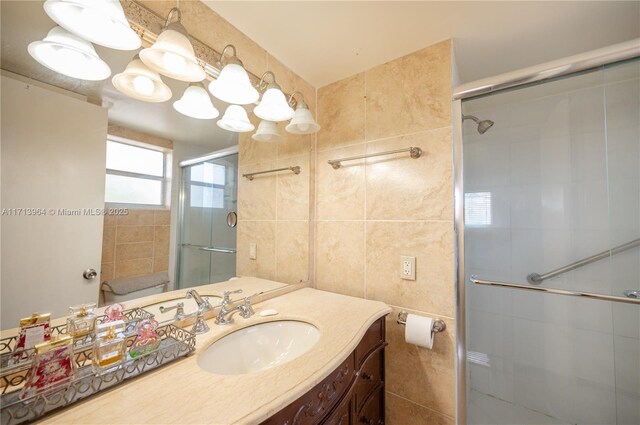 bathroom featuring vanity, a shower with door, and tile walls