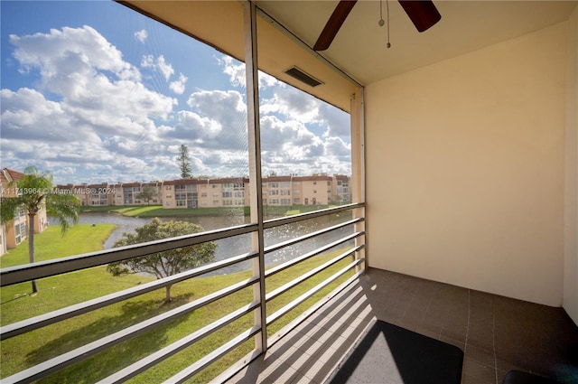 balcony featuring ceiling fan and a water view