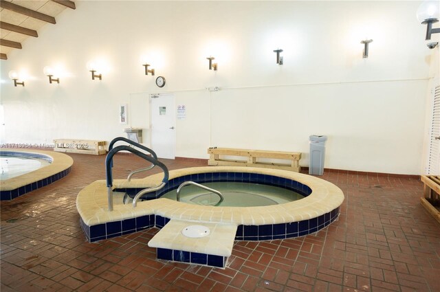 view of swimming pool with an indoor hot tub