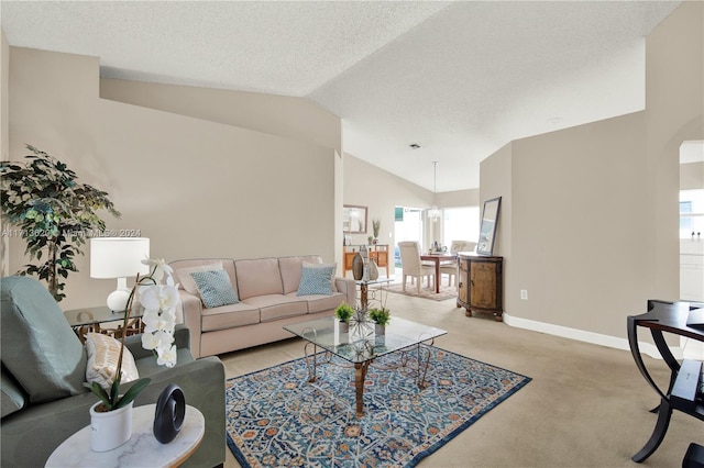 carpeted living room with a textured ceiling and vaulted ceiling