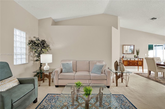 living room featuring a textured ceiling, light carpet, and lofted ceiling