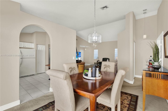 dining room featuring light tile patterned floors, a chandelier, and vaulted ceiling