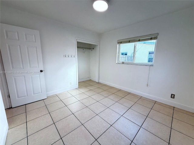 unfurnished bedroom featuring a closet and light tile patterned flooring