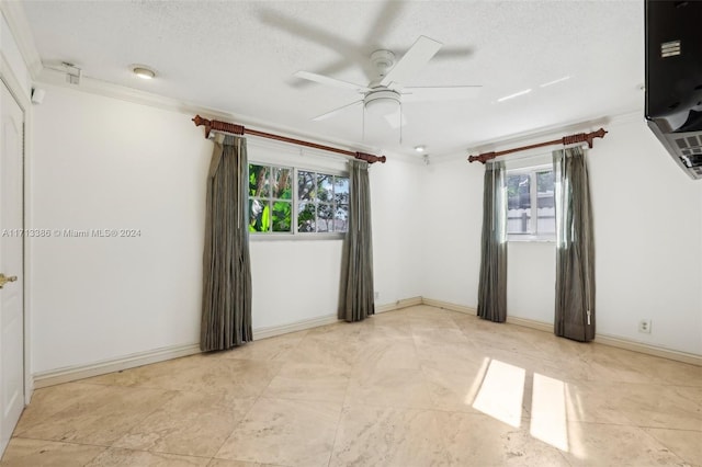 unfurnished room with a wealth of natural light, crown molding, ceiling fan, and a textured ceiling