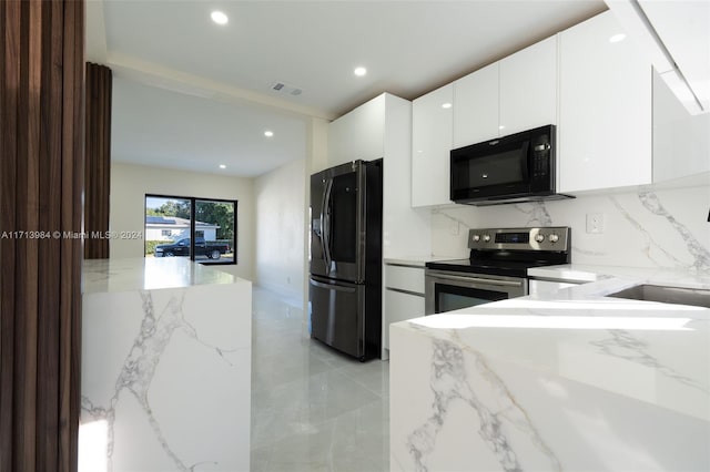 kitchen featuring white cabinetry, light stone counters, and black appliances