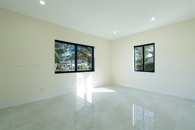 tiled spare room featuring a healthy amount of sunlight