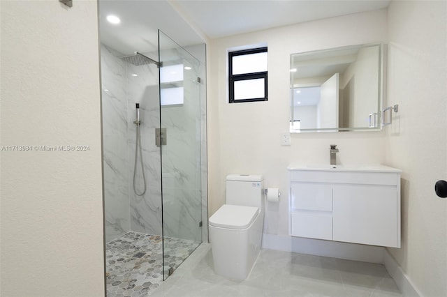 bathroom with vanity, toilet, and tiled shower