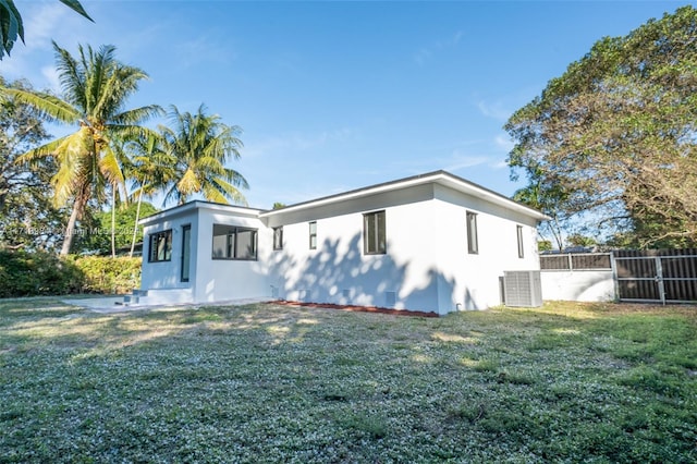 view of side of home with a lawn and central AC