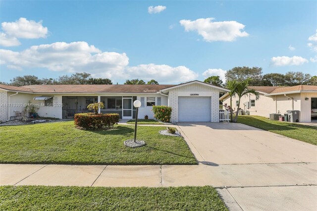 single story home featuring a garage and a front lawn