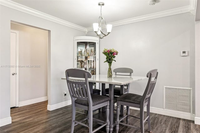 dining area with a chandelier, crown molding, and dark wood-type flooring