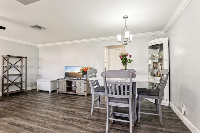 dining room with dark wood-type flooring, crown molding, and an inviting chandelier