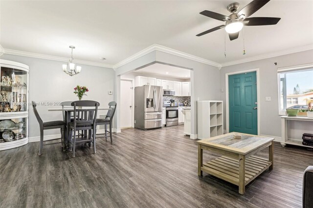 dining space with crown molding, dark hardwood / wood-style flooring, and ceiling fan with notable chandelier