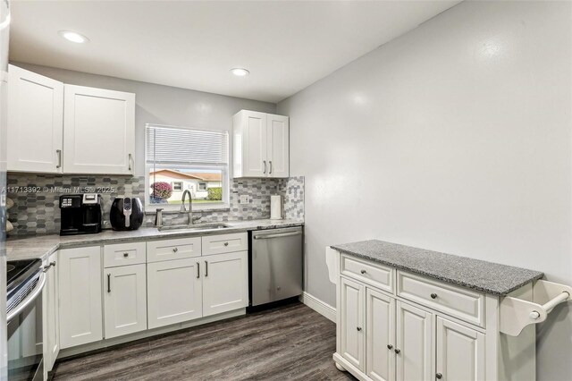 kitchen with appliances with stainless steel finishes, sink, white cabinetry, and light stone countertops