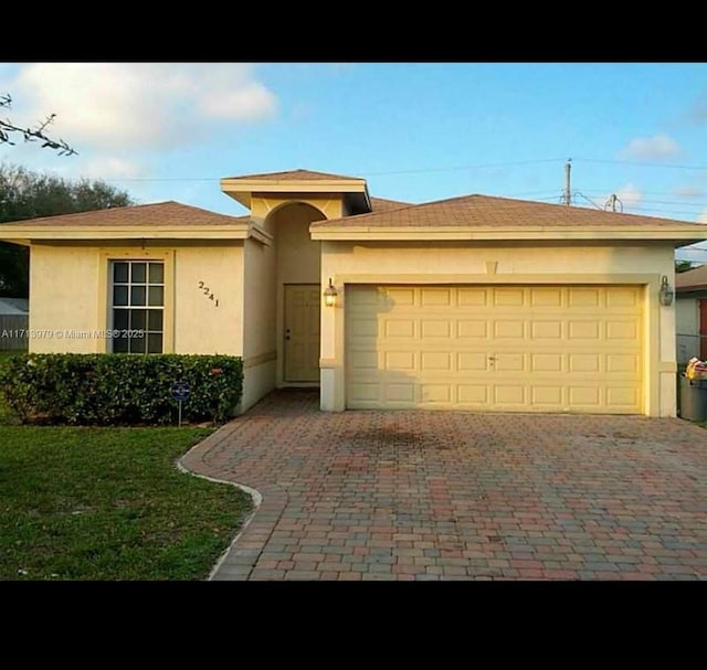 view of front of home featuring a front yard and a garage