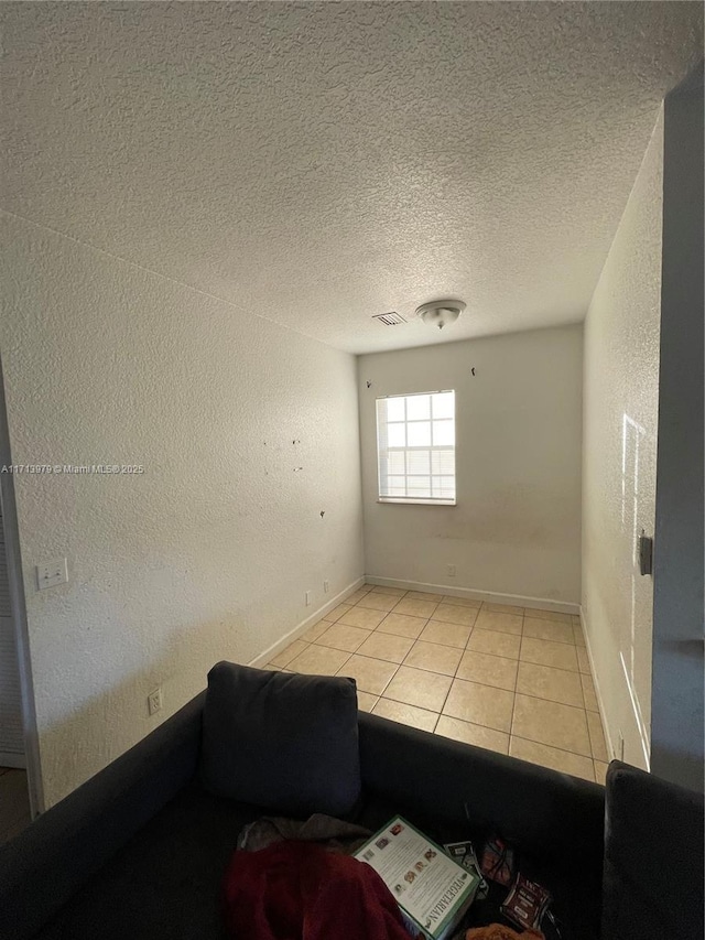 tiled spare room with a textured ceiling