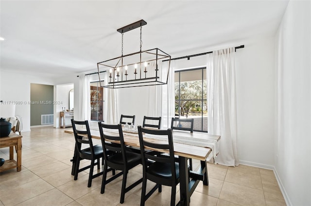 dining space featuring light tile patterned floors and a chandelier