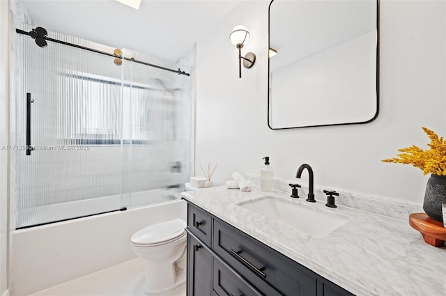 full bathroom with enclosed tub / shower combo, vanity, and toilet