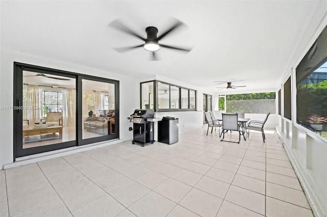 unfurnished sunroom featuring ceiling fan and a healthy amount of sunlight