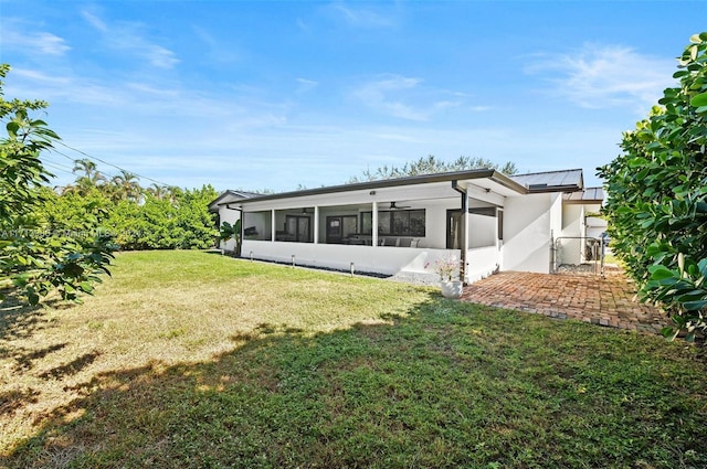 rear view of property with a sunroom and a yard