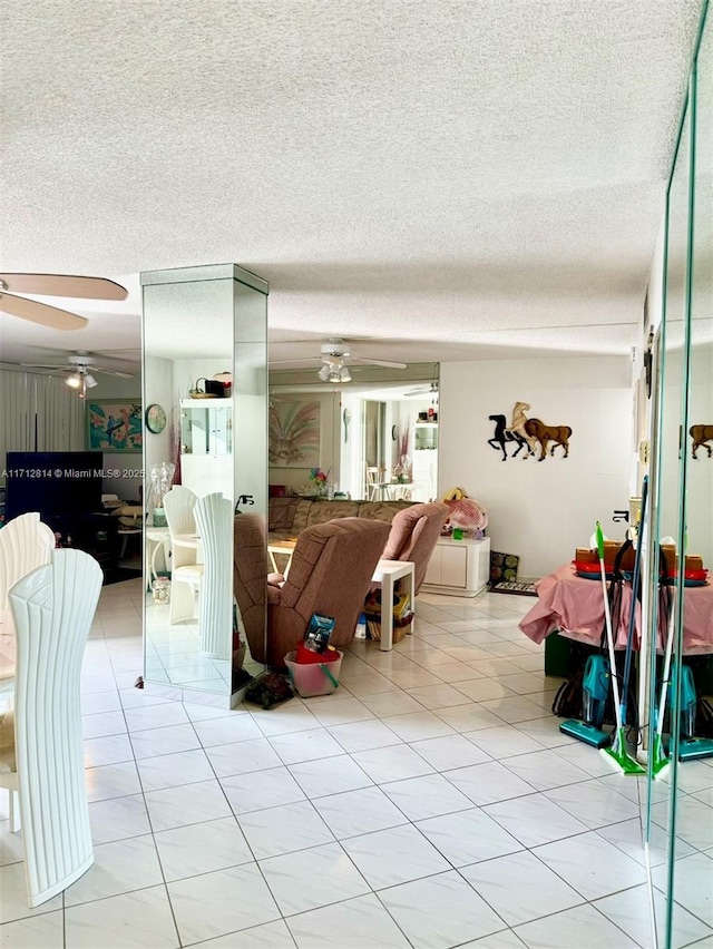 tiled living room featuring ceiling fan and a textured ceiling