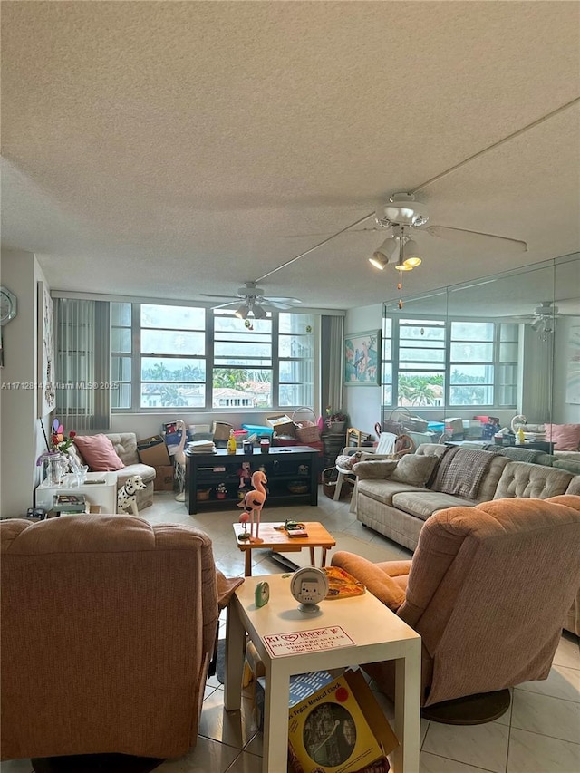 tiled living room featuring ceiling fan and a textured ceiling