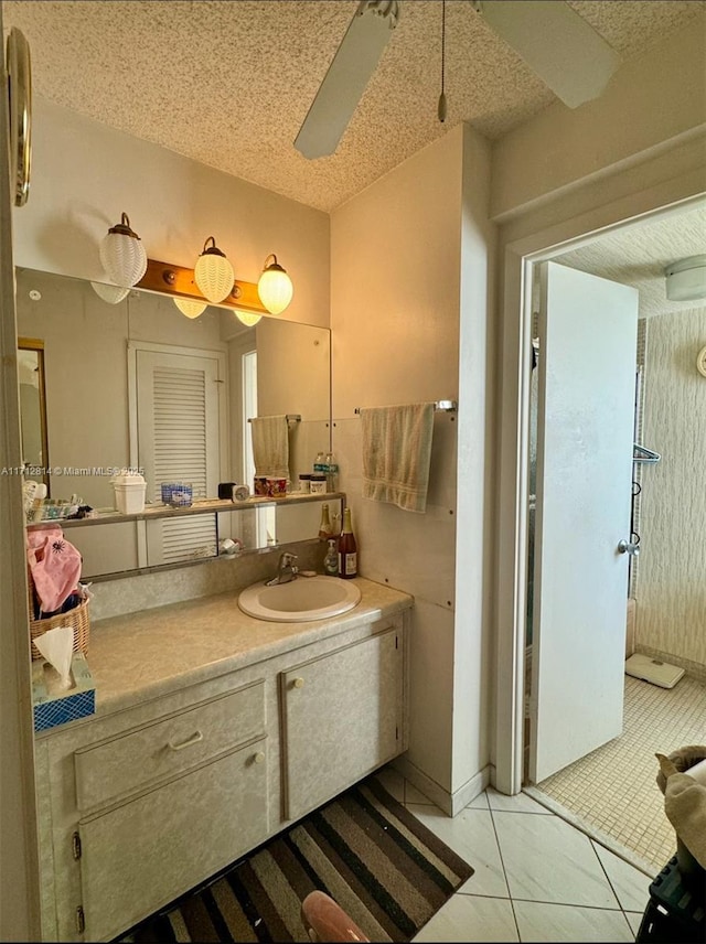 bathroom featuring vanity, ceiling fan, tile patterned floors, and a textured ceiling