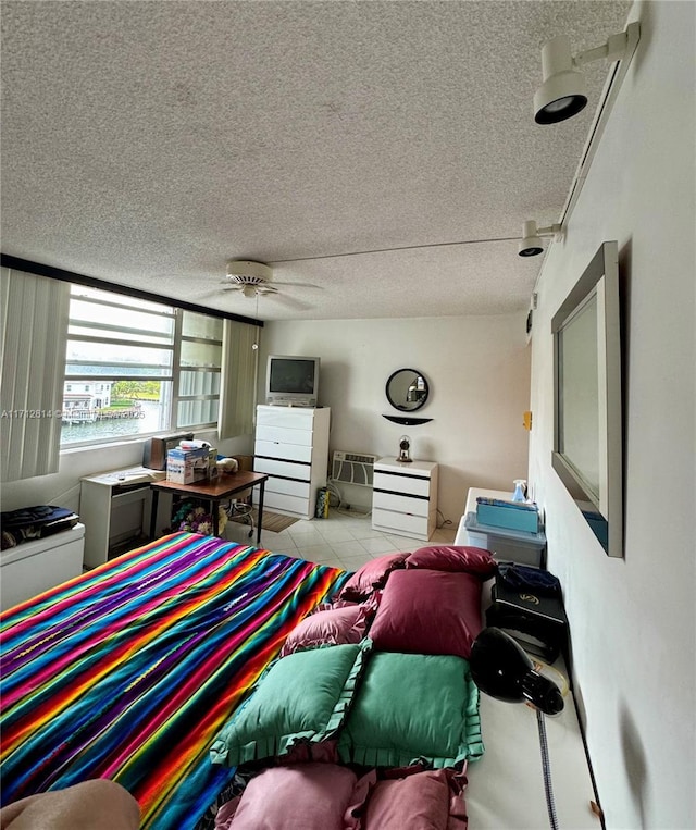 living room featuring ceiling fan, a textured ceiling, and light tile patterned floors