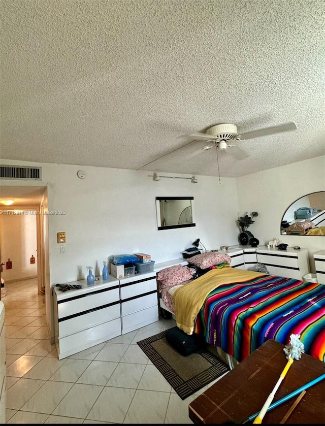 bedroom featuring light tile patterned floors, a textured ceiling, and ceiling fan