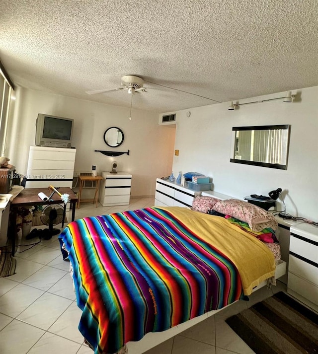 bedroom with light tile patterned flooring, ceiling fan, and a textured ceiling